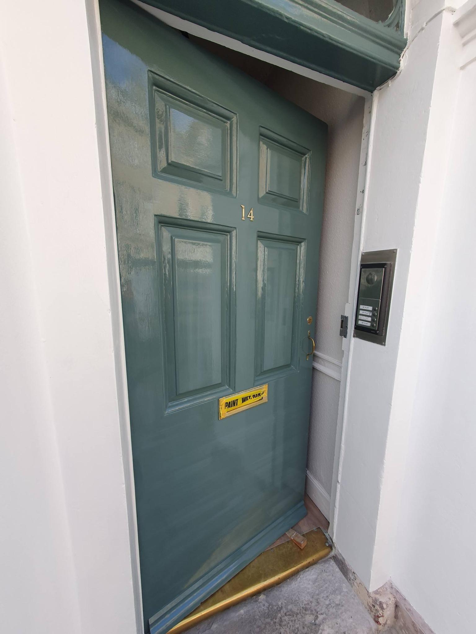 Close-up of freshly painted teal green Georgian front door, number 14, with brass letterbox