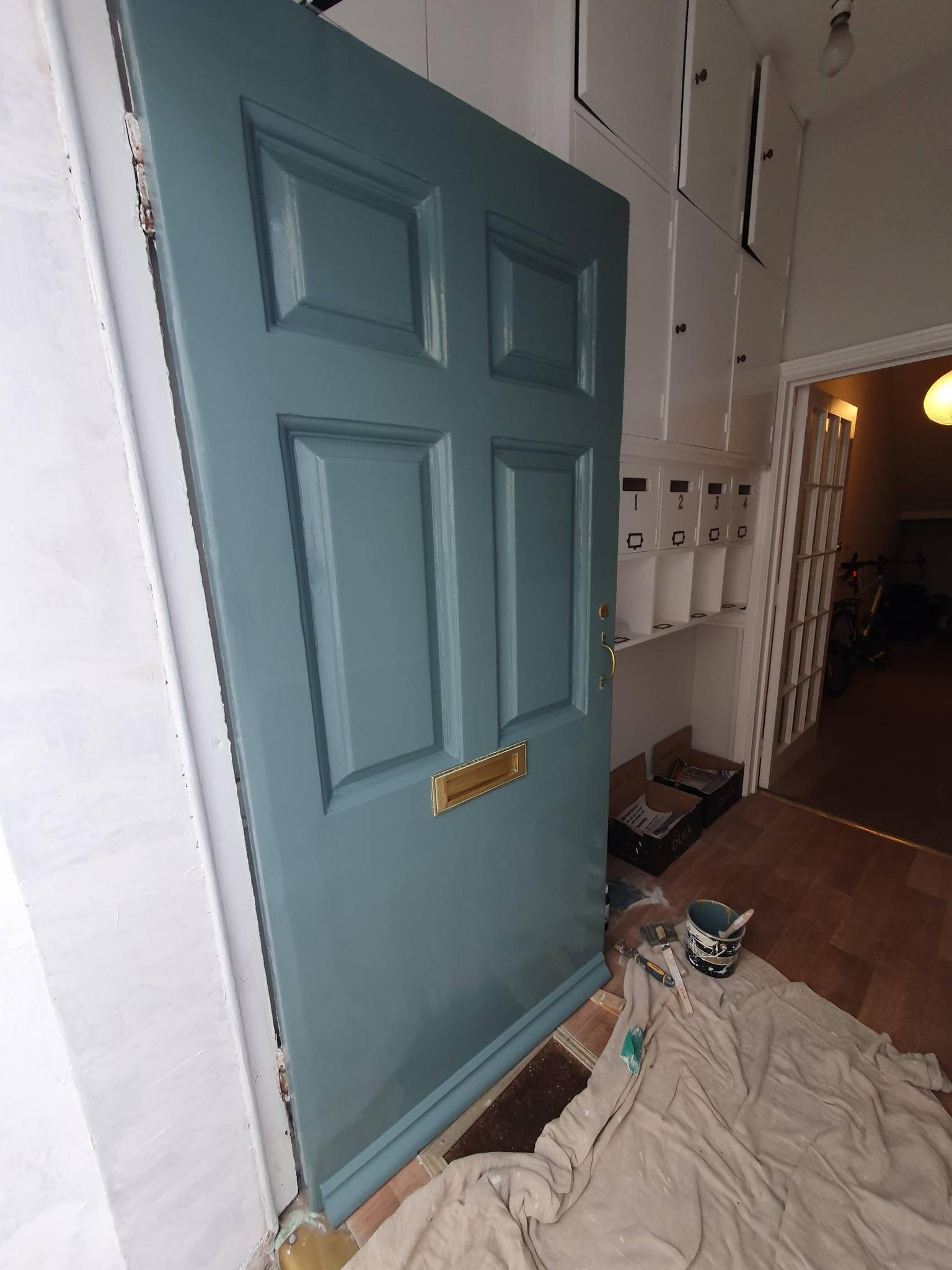 Interior view of freshly painted teal green Georgian front door with brass letterbox