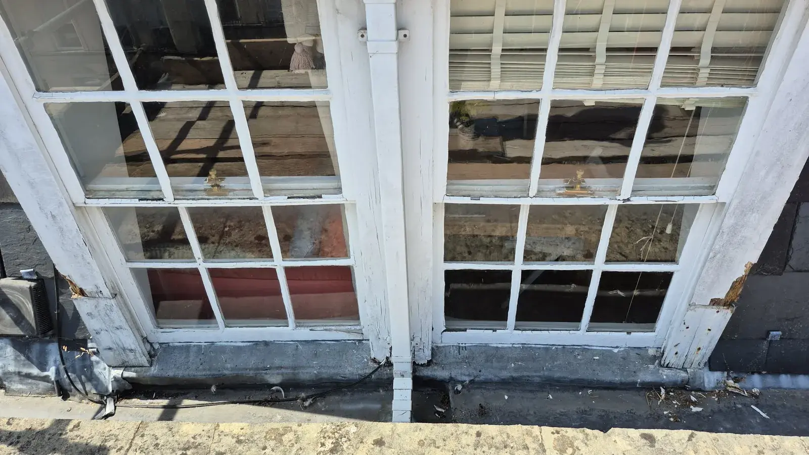 Pair of Georgian sash windows with cracked and flaking paintwork before redecoration, Bath