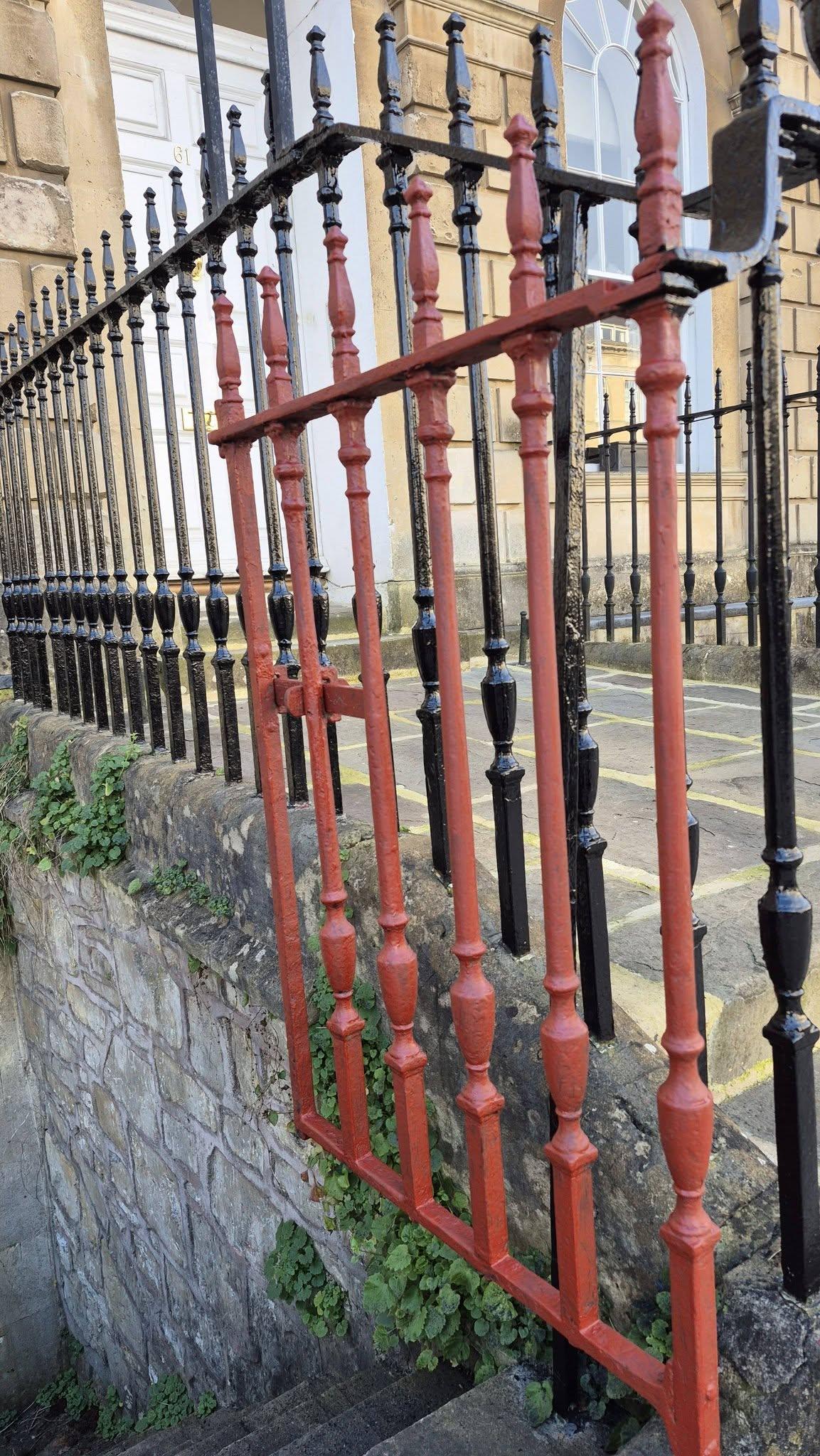 Faded red and black railings before – Bath